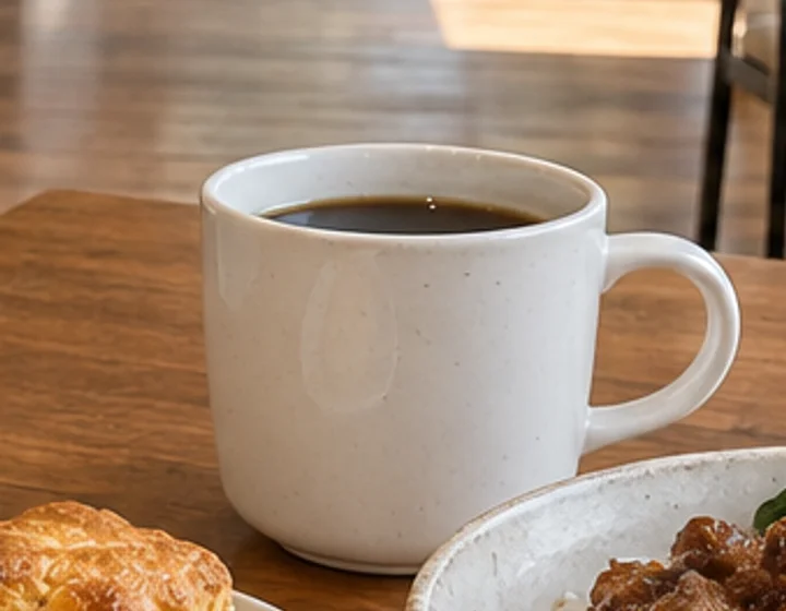 木のテーブルの上の白いコーヒーカップ