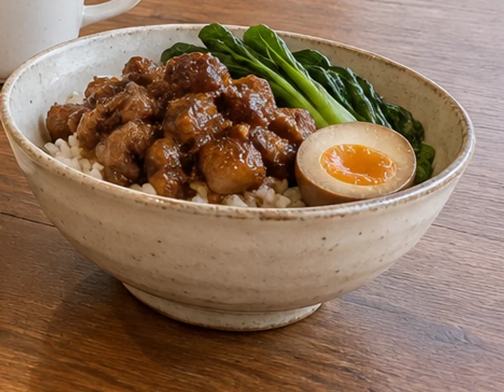 白い器に盛った煮込み肉のごはんと青菜